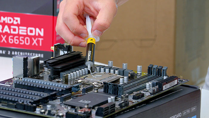 Applying thermal paste on a CPU during the step-by-step PC build process as part of a computer build checklist, essential in the steps of building a PC.