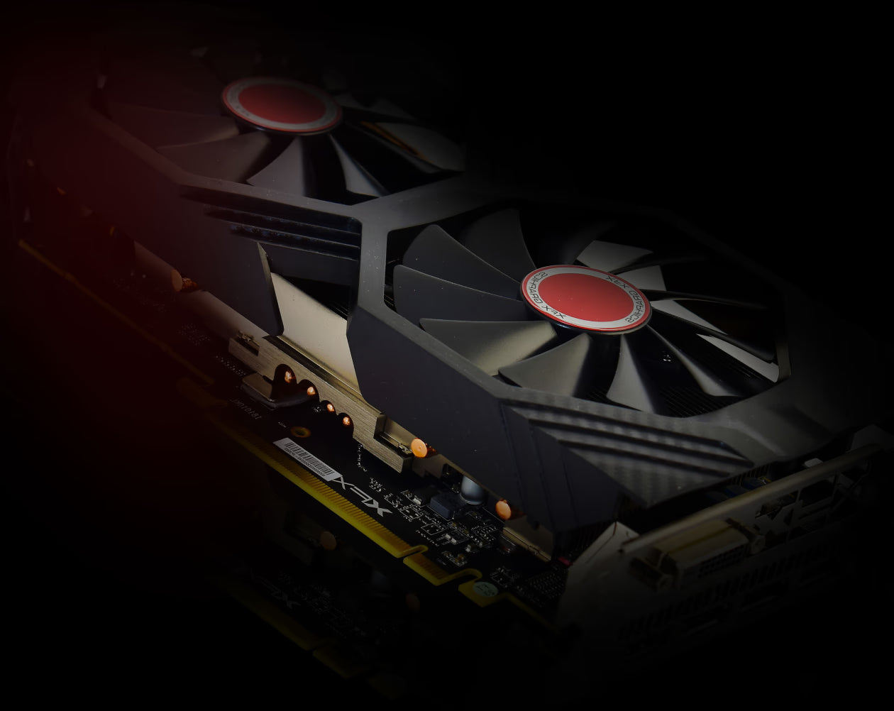 Close-up of a dual-fan XFX AMD Radeon RX 580 graphics card glowing in red light